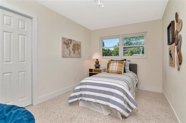 bedroom with speckled floor and baseboards