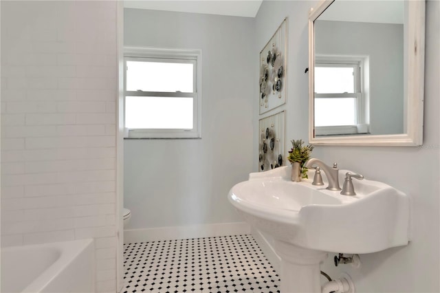 bathroom featuring toilet and baseboards