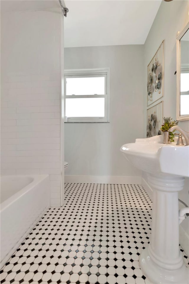 bathroom featuring tile patterned floors, toilet, and baseboards