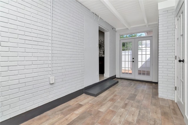 interior space with beam ceiling and french doors