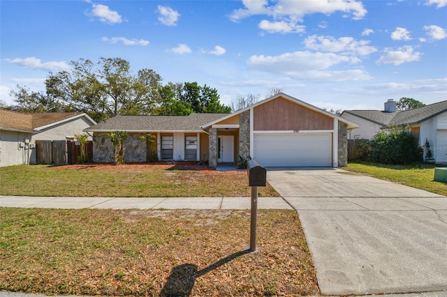 view of front of home featuring concrete driveway, fence, a garage, stone siding, and a front lawn