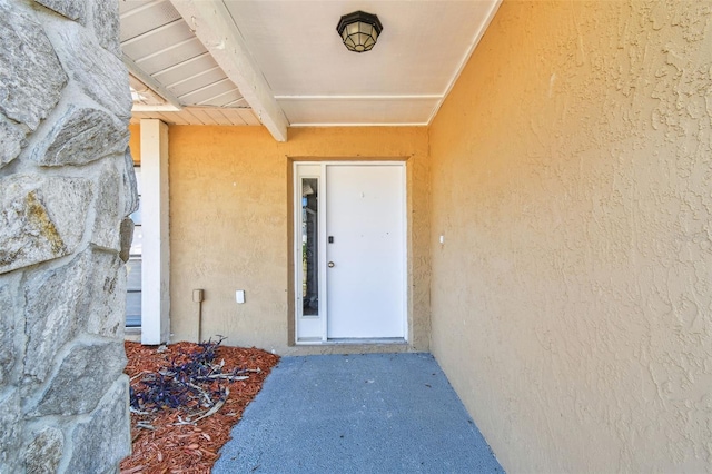 doorway to property featuring stucco siding