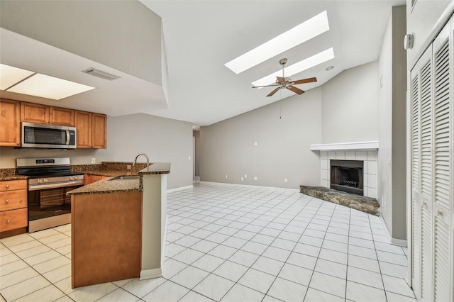 kitchen featuring visible vents, appliances with stainless steel finishes, open floor plan, a peninsula, and a sink