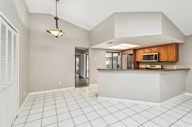 kitchen with visible vents, brown cabinetry, hanging light fixtures, stainless steel appliances, and light tile patterned flooring