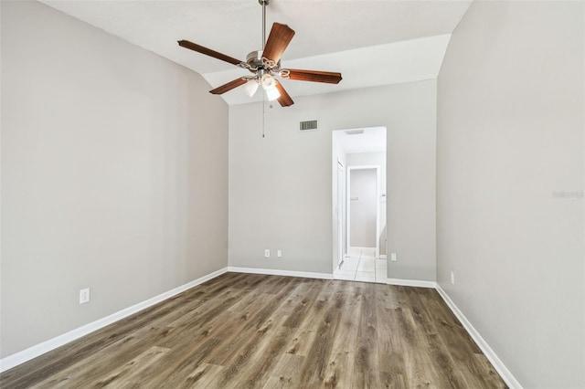 empty room with visible vents, ceiling fan, baseboards, and wood finished floors