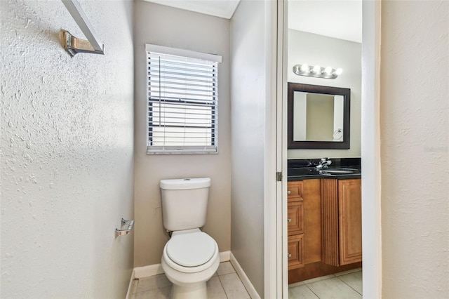 bathroom with toilet, tile patterned flooring, vanity, and baseboards