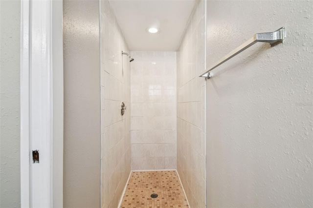 full bathroom featuring a stall shower and a textured wall