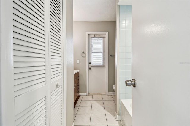 full bathroom featuring baseboards, toilet, tile patterned floors, vanity, and a closet