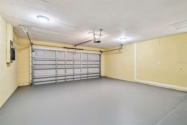 garage featuring a garage door opener and concrete block wall