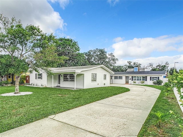 ranch-style house with driveway and a front yard