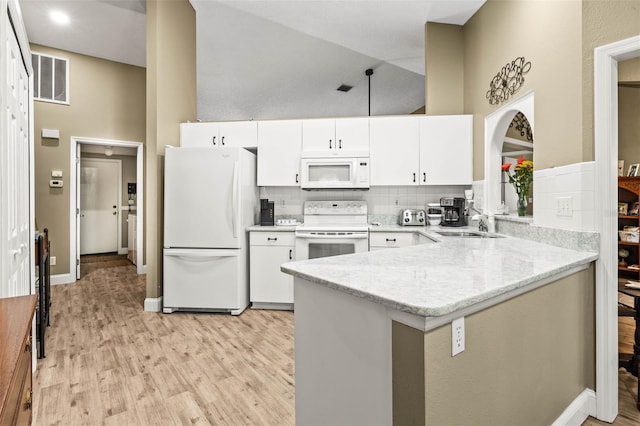 kitchen featuring white appliances, visible vents, a peninsula, light wood-type flooring, and white cabinetry