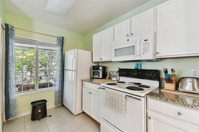 kitchen with light tile patterned floors, white appliances, stone countertops, and white cabinets