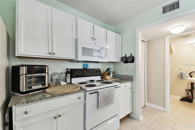 kitchen featuring a textured ceiling, light tile patterned flooring, white appliances, visible vents, and white cabinetry