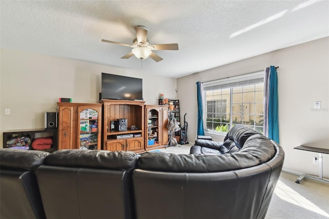 carpeted living room featuring a ceiling fan and a textured ceiling