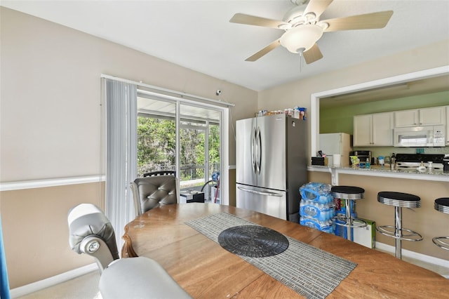 dining space with baseboards and a ceiling fan