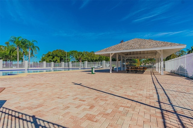 view of property's community featuring a gazebo, a swimming pool, and fence