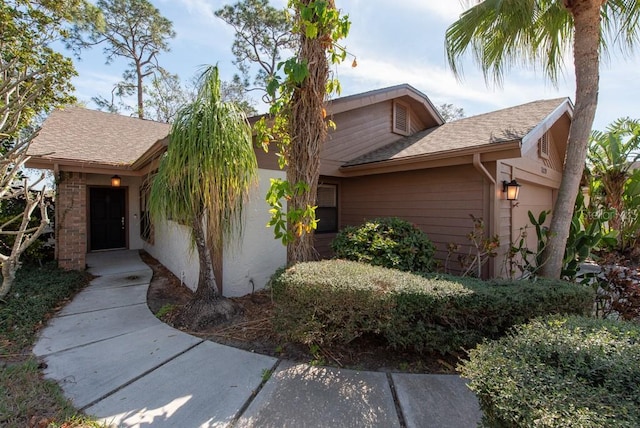 view of front of property featuring an attached garage and a shingled roof