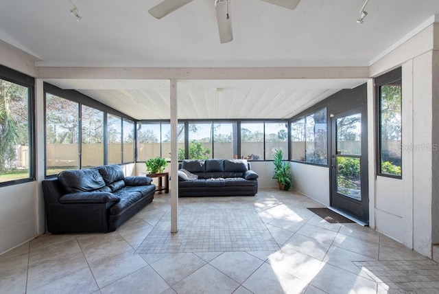 sunroom / solarium featuring rail lighting, vaulted ceiling, and a ceiling fan