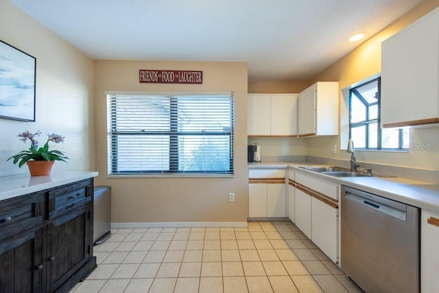 kitchen featuring white cabinets, light countertops, stainless steel dishwasher, a sink, and light tile patterned flooring