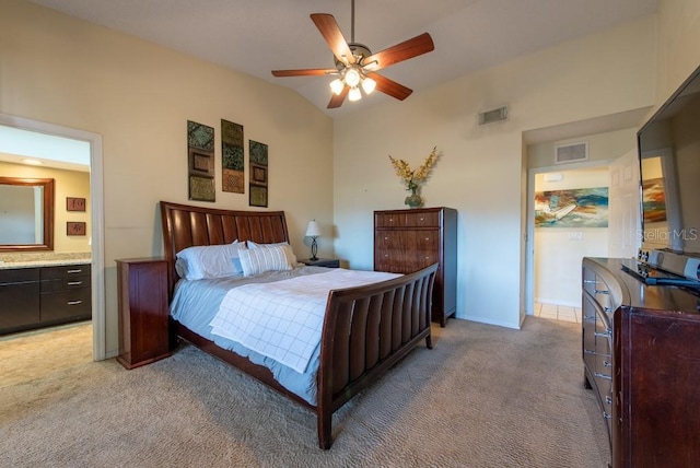 bedroom with visible vents, vaulted ceiling, connected bathroom, and light colored carpet