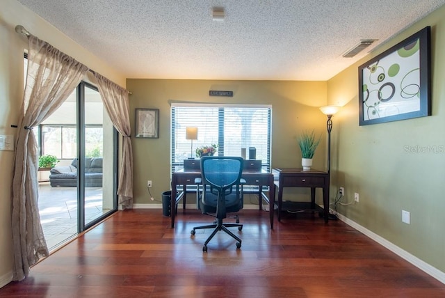 office space featuring visible vents, dark wood finished floors, a textured ceiling, and baseboards