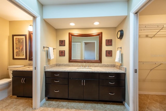 full bath with recessed lighting, toilet, a spacious closet, and vanity