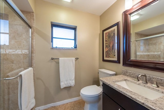 full bath with toilet, baseboards, a tile shower, and vanity