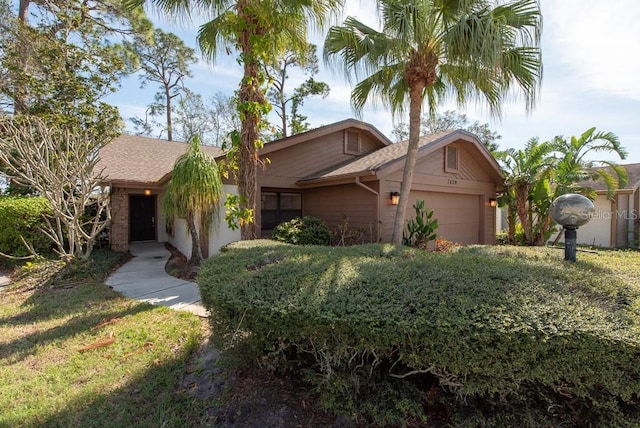 view of front of home featuring a front lawn, roof with shingles, and an attached garage