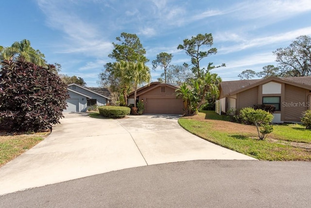 view of front of home featuring driveway, a front lawn, an attached garage, and stucco siding