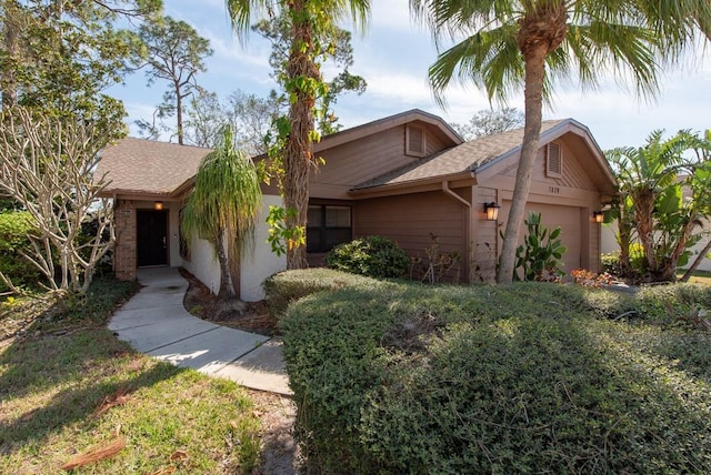 view of front facade with a garage and roof with shingles