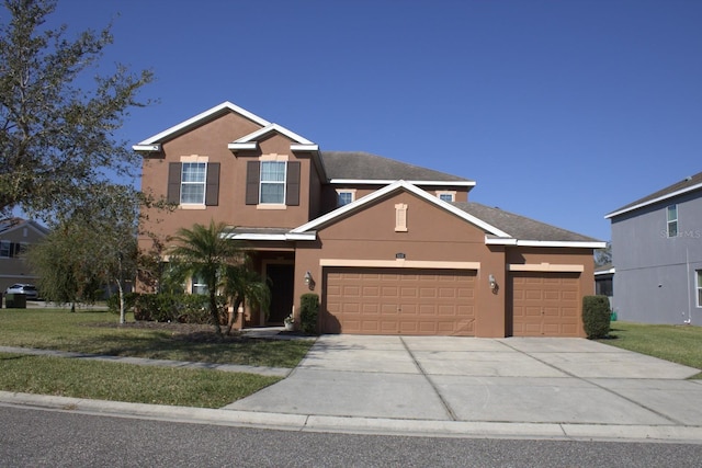 view of front facade featuring a garage, driveway, a front lawn, and stucco siding