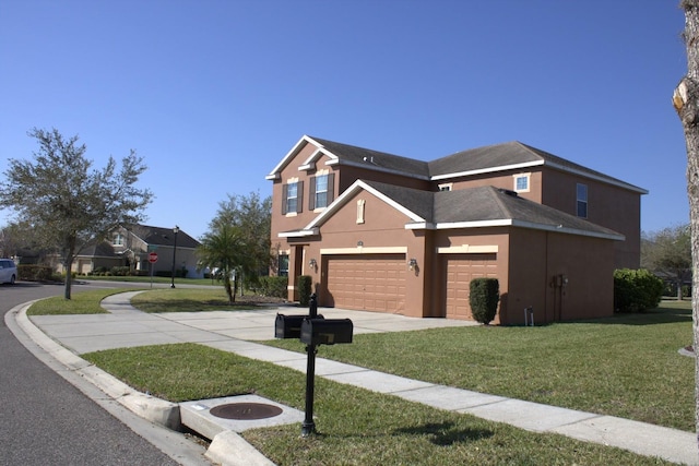 view of front of home featuring driveway, stucco siding, and a front yard