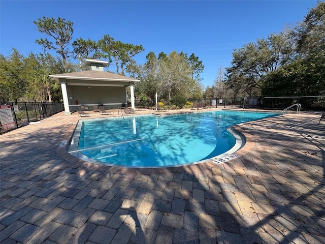 community pool with a patio and fence