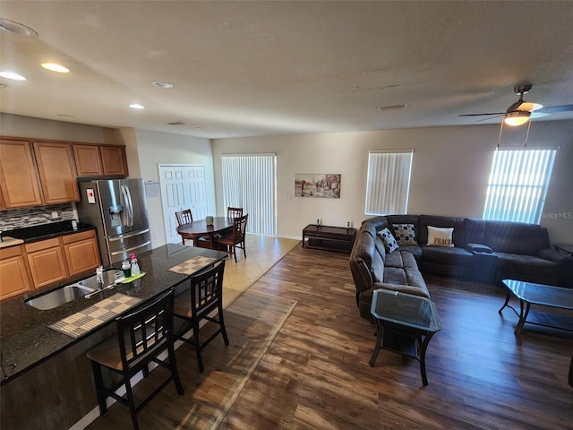 living area with dark wood-style flooring, recessed lighting, visible vents, ceiling fan, and a textured ceiling