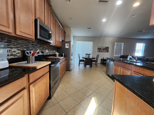 kitchen featuring tasteful backsplash, visible vents, appliances with stainless steel finishes, light tile patterned flooring, and a sink