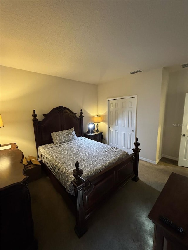 carpeted bedroom with a textured ceiling, a closet, visible vents, and baseboards