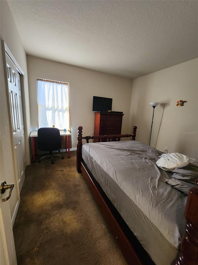 bedroom with carpet floors, baseboards, and a textured ceiling