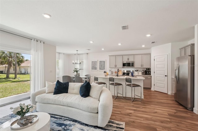 4754 Easter Ter, North Port, FL 34286 - living room with an inviting chandelier, wood finished floors, recessed lighting, and visible vents
