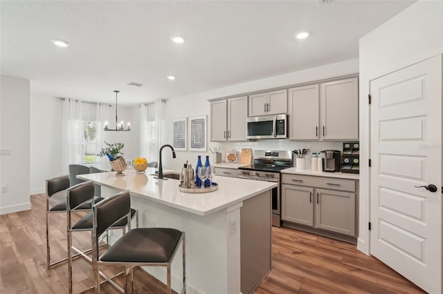 4754 Easter Ter, North Port, FL 34286 - kitchen with gray cabinetry, a kitchen bar, a sink, and appliances with stainless steel finishes