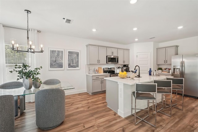 4754 Easter Ter, North Port, FL 34286 - kitchen featuring a kitchen breakfast bar, gray cabinetry, stainless steel appliances, and recessed lighting