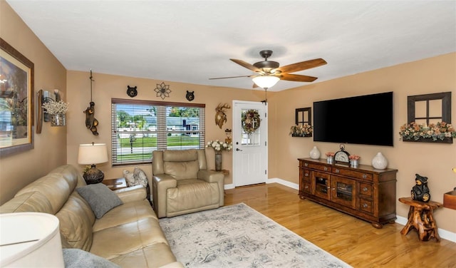 living area with ceiling fan, baseboards, and wood finished floors