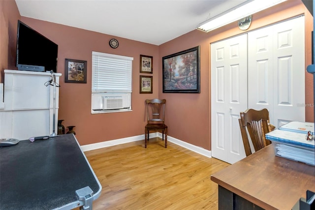 office space featuring cooling unit, baseboards, and wood finished floors