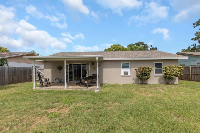 rear view of property with roof with shingles, a lawn, a patio area, and a fenced backyard