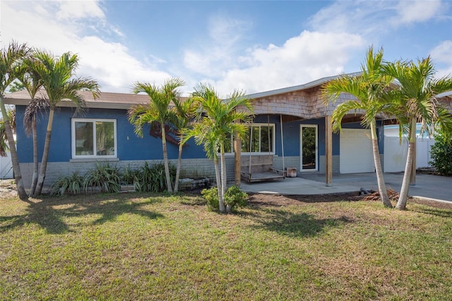 view of front of home with a front yard, a patio area, and stucco siding