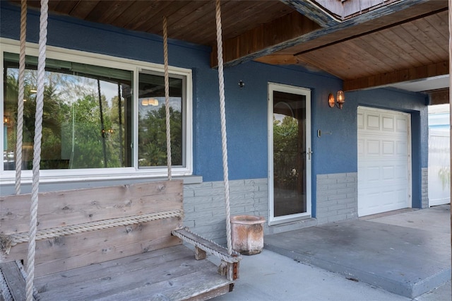 property entrance featuring a garage and stucco siding