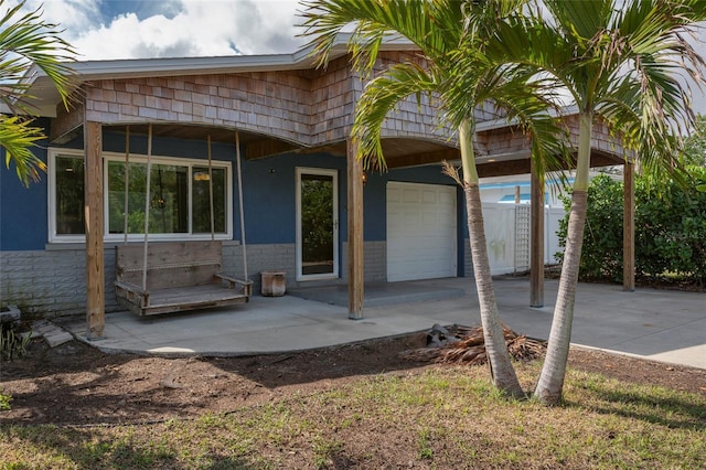 exterior space with concrete driveway, an attached garage, and stucco siding