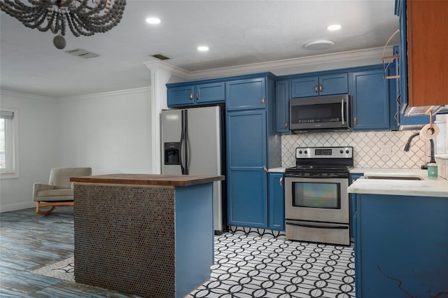 kitchen with ornamental molding, light countertops, appliances with stainless steel finishes, and blue cabinetry