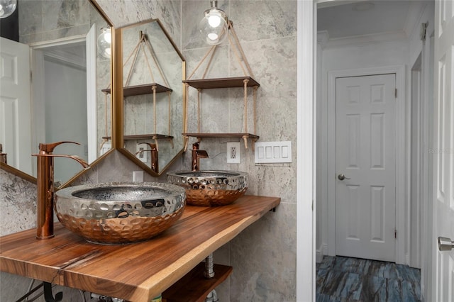 interior details with a sink, crown molding, and wood finished floors