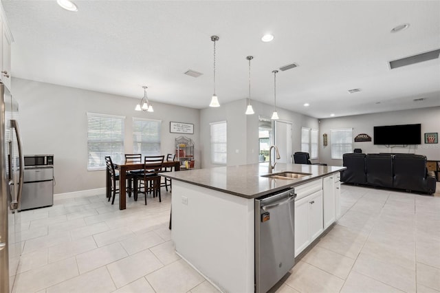 kitchen featuring visible vents, dark countertops, stainless steel appliances, white cabinetry, and a sink