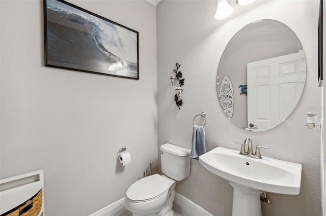 bathroom with baseboards, a sink, and toilet